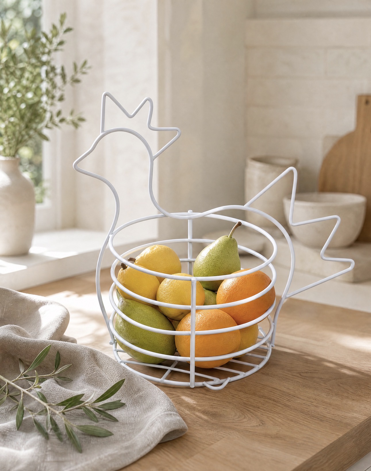 Gallina Multiusos GINLU con limones, naranjas y peras sobre mesa de madera junto a una ventana iluminada